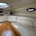 Regal 2665 - Dining table, speakers and port lights in the main cabin